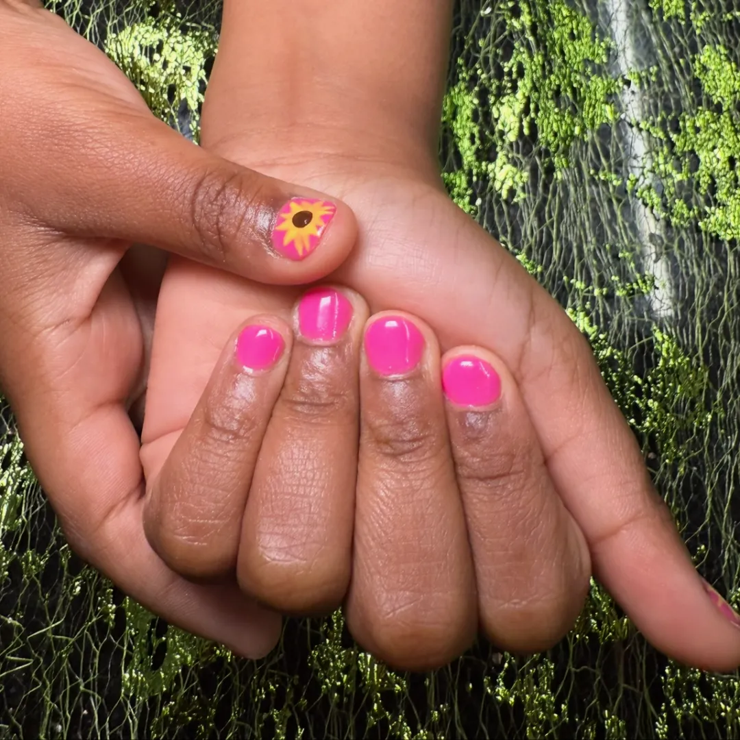 Hot pink short nails with a sunflower accent nail