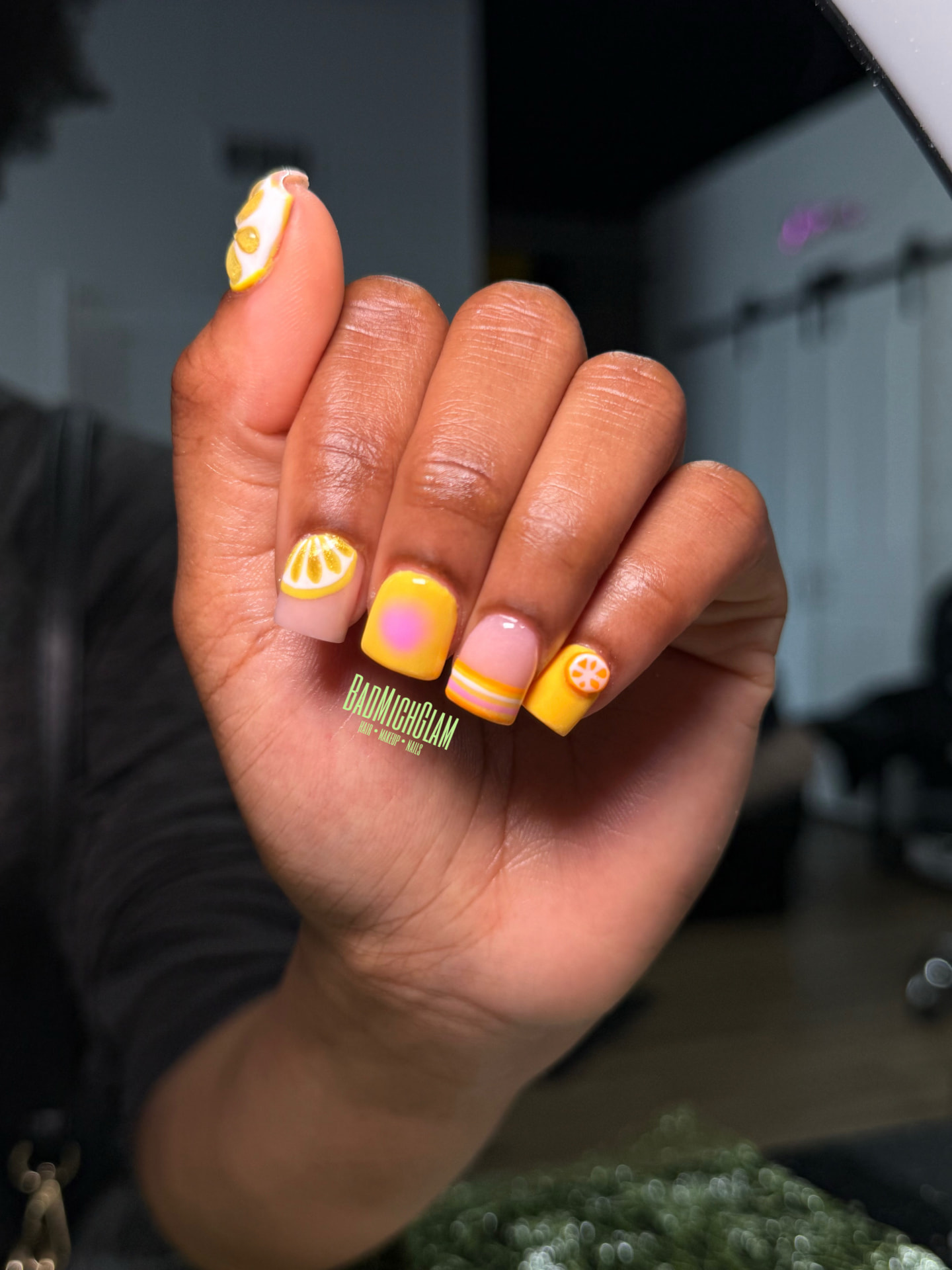 Short square nails with yellow lemon slices, citrus accents and pastel French tips